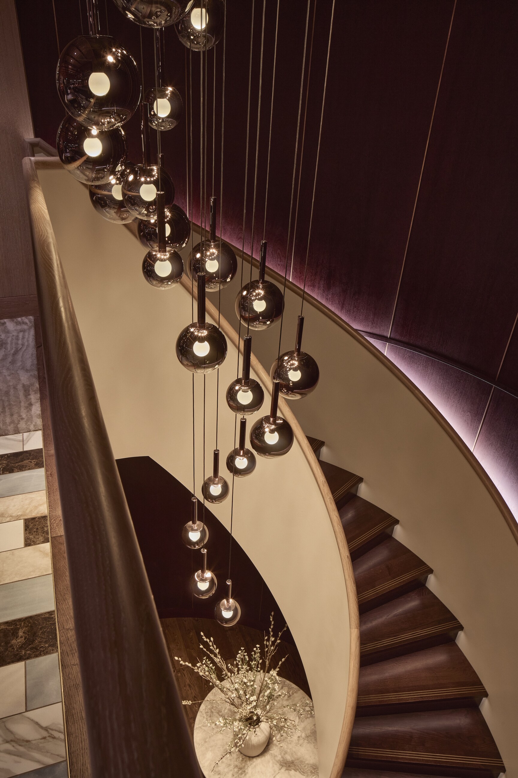 Mehrere Luna sospeso Leuchten erhellen die Wendeltreppe