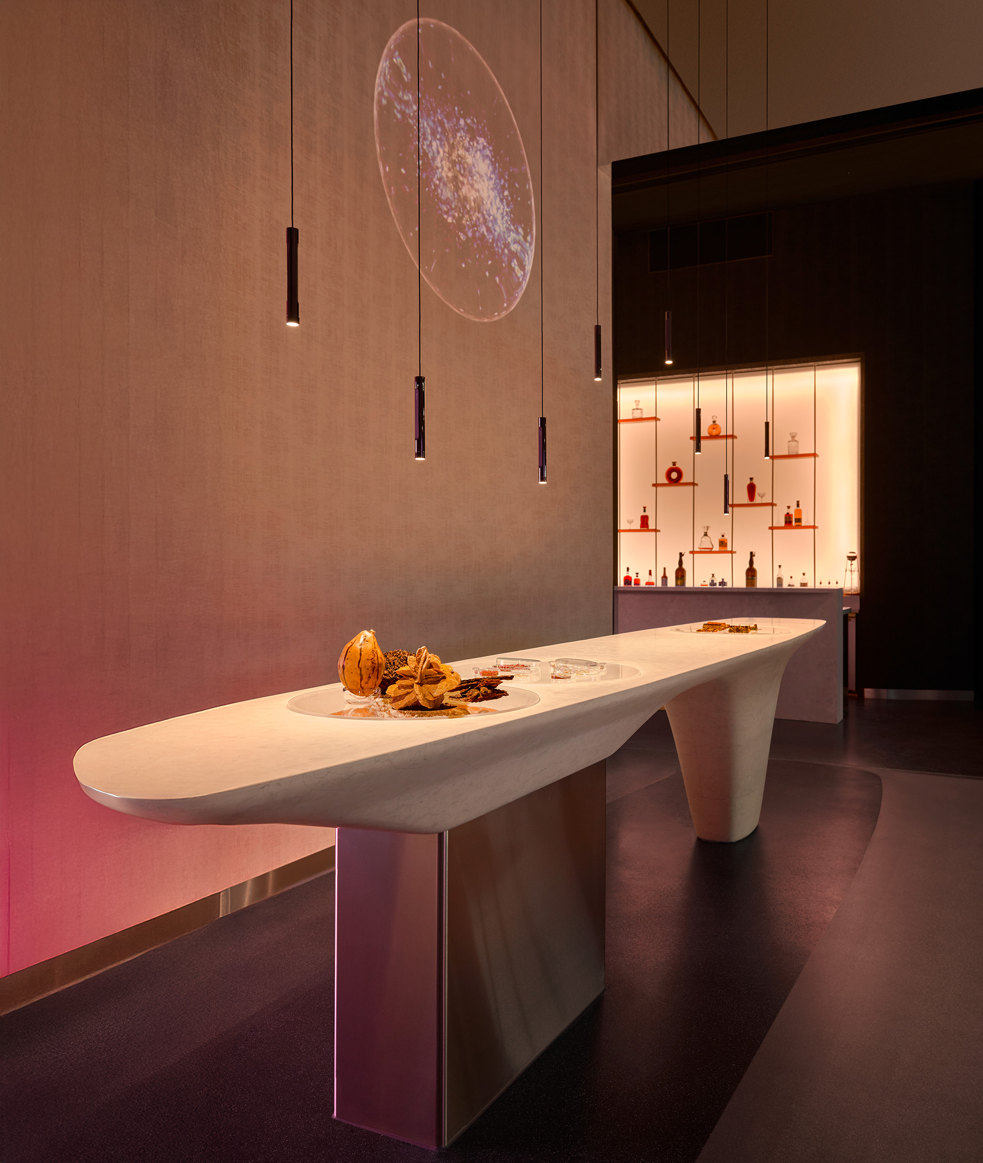 Tresen der Biophilic Bar im Fine Dining Restaurant The Cloud by Käfer mit Coro sospeso Pendelleuchten von Occhio und Projektion auf Perlino-Marmor