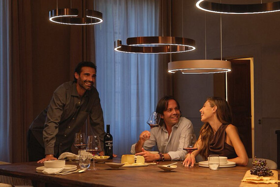 Occhio Mito sospeso illuminating table whilst people having dinner