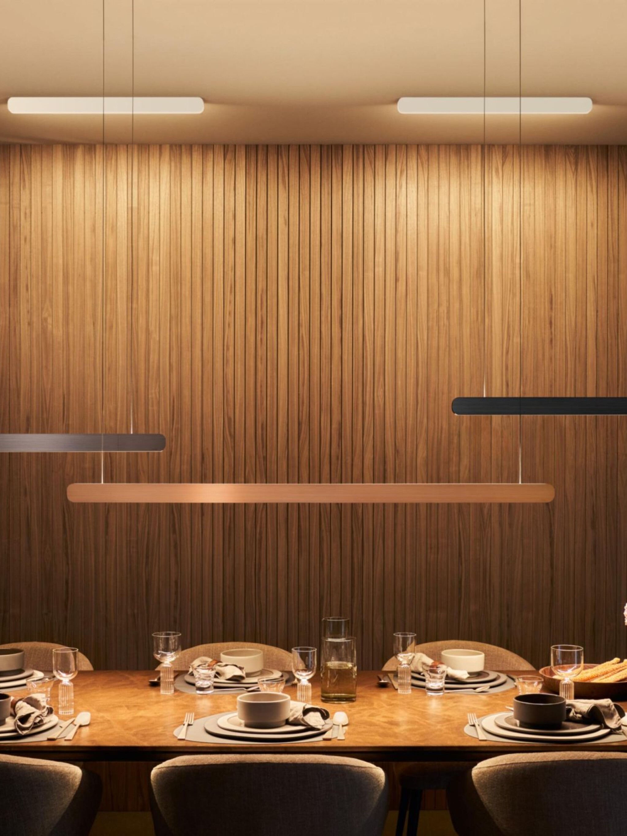 Mito linear volo pendant luminaire above long dining table