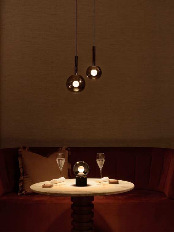 Tisch in einem Restaurant beleuchtet durch drei Occhio Luna Leuchten