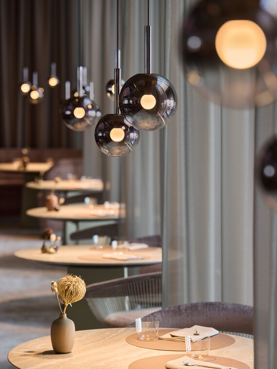 Runde Tische im Restaurant the Cloud von Luna sospeso illuminiert