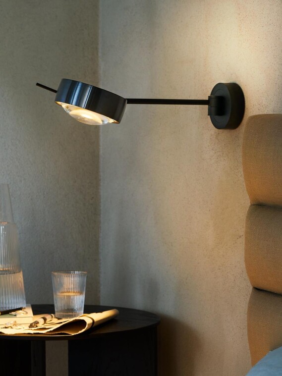 Occhio sento lettura next to bed on grey concrete wall