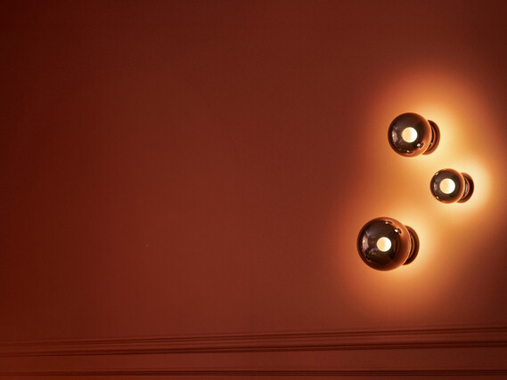 Occhio Luna scura design glass wall luminaire on warm toned wall