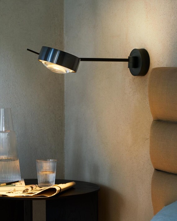 Occhio sento lettura next to bed on grey concrete wall